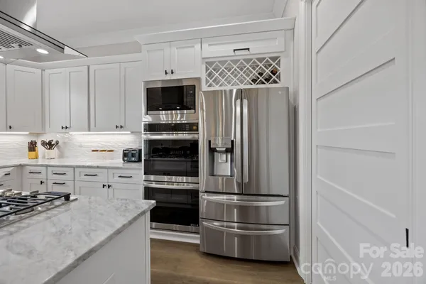 a kitchen with stainless steel appliances white cabinets and a stove