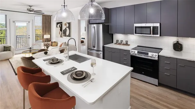 a kitchen with stainless steel appliances a stove a sink a microwave and refrigerator