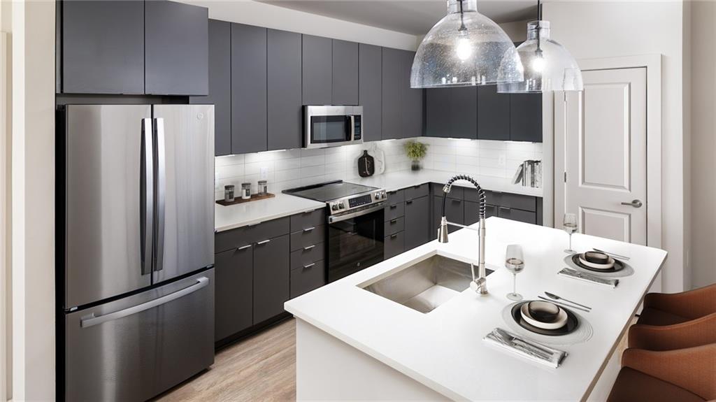 3100 Commerce Avenue Northwest, Unit C1 Duluth, GA 30096 - Photo 19 of 27 a kitchen with stainless steel appliances granite countertop a sink stove and refrigerator