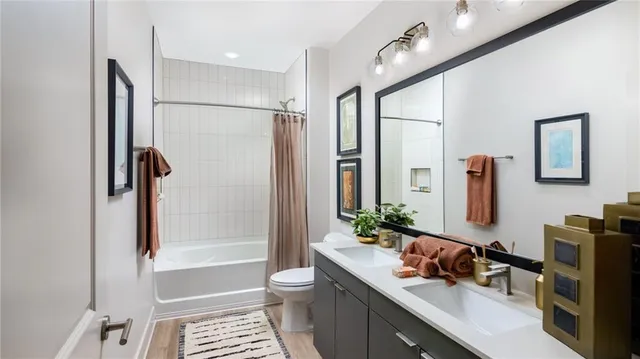 a bathroom with a granite countertop sink a mirror a bathtub and shower