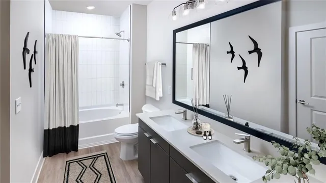 a bathroom with a double vanity sink a toilet and a mirror