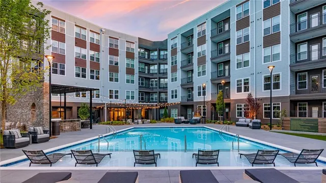 a view of building with swimming pool and outdoor seating