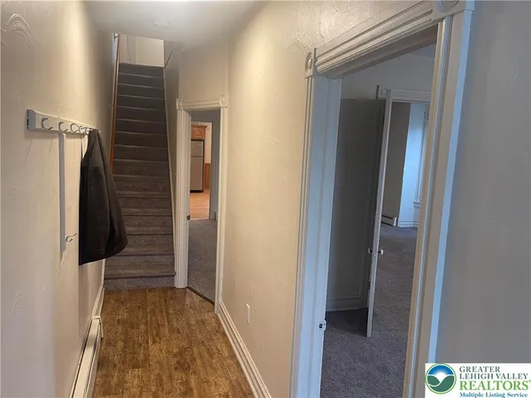 a view of a hallway with wooden floor and staircase