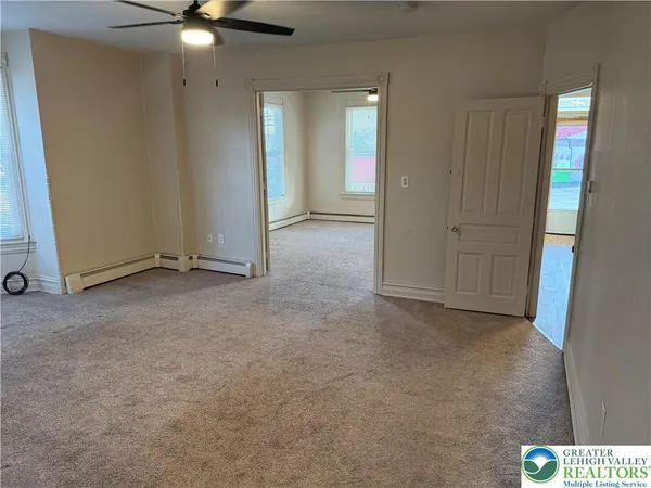 an empty room with closet and fan