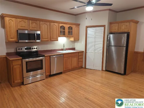 a kitchen with stainless steel appliances a stove a sink and a microwave