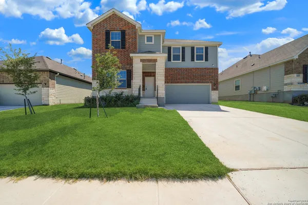 a front view of a house with a yard and garage