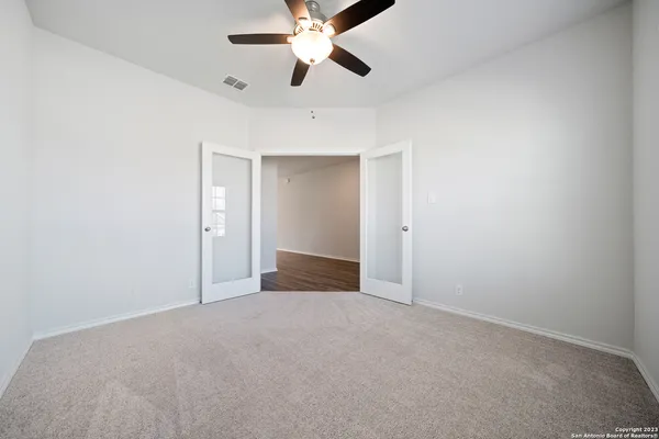 an empty room with closet and a chandelier fan