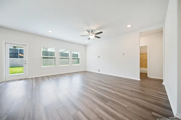 a view of an empty room with a window and wooden floor