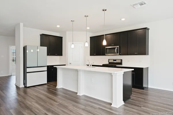 a kitchen with stainless steel appliances a stove a sink and a microwave