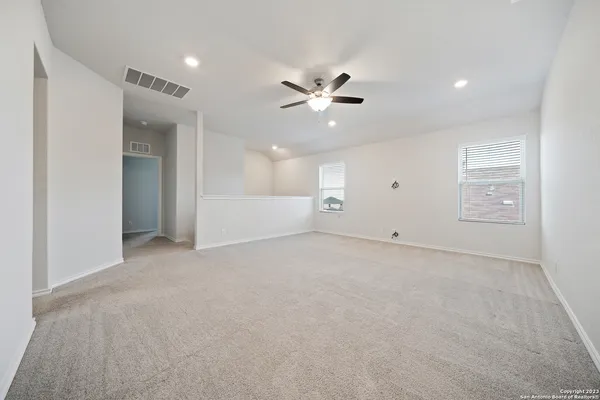 an empty room with fan and windows