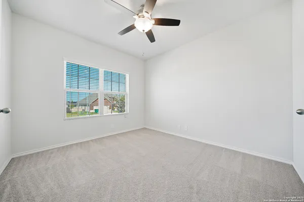 an empty room with window and ceiling fan