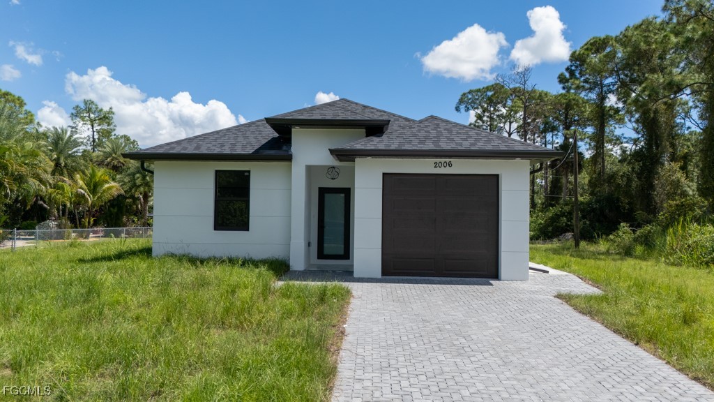 a front view of a house with a yard and garage