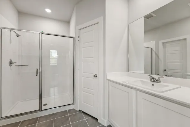 a bathroom with a shower sink and mirror