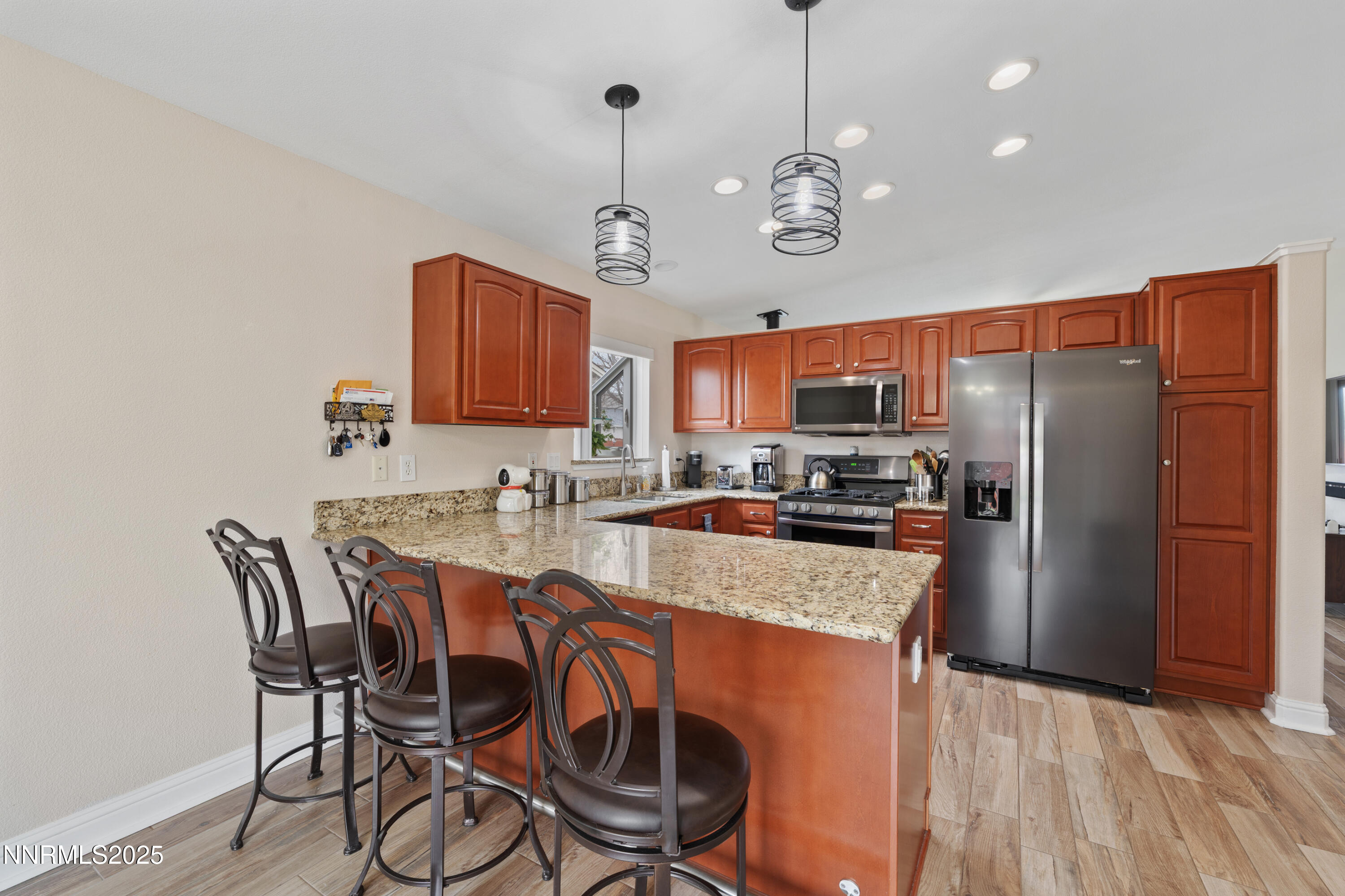 17785 Fortune Court Reno, NV 89508 - Photo 14 of 43 a kitchen with stainless steel appliances granite countertop a refrigerator a stove a sink dishwasher a dining table and chairs with wooden floor
