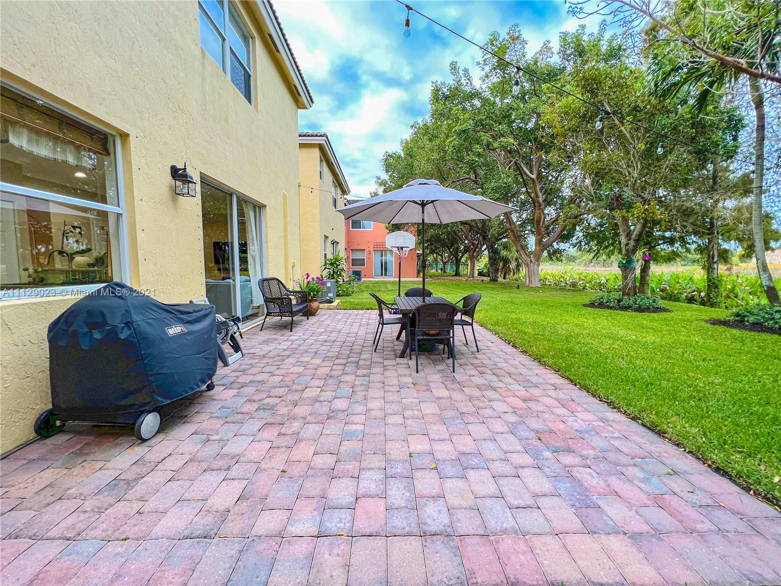 1399 Southeast 20th Road Homestead, FL 33035 - Photo 32 of 50 a view of a patio with a table and chairs under an umbrella