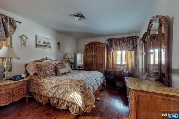 a spacious bedroom with a bed and a mirror