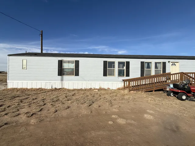 a backyard of a house with wooden fence and trees