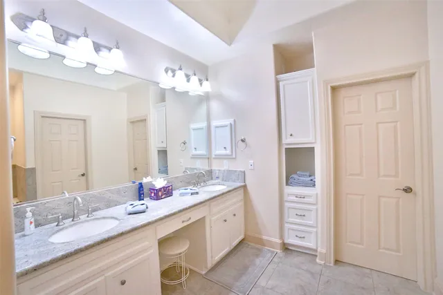 a spacious bathroom with a granite countertop sink a mirror and a shower