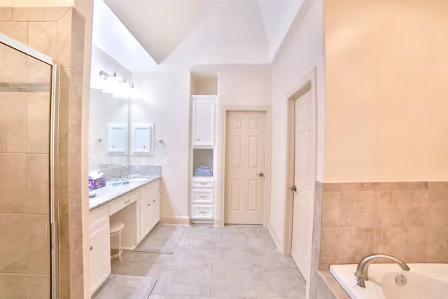 a bathroom with a granite countertop sink a mirror and a bathtub