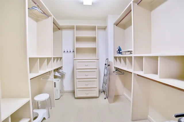 a view of walk in closet with empty racks