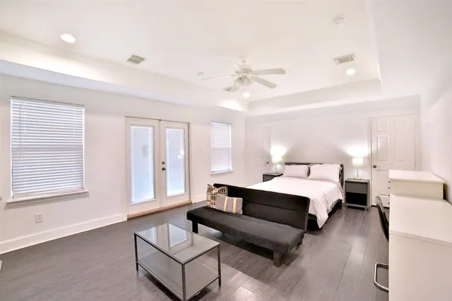 a spacious bedroom with a bed couch and window