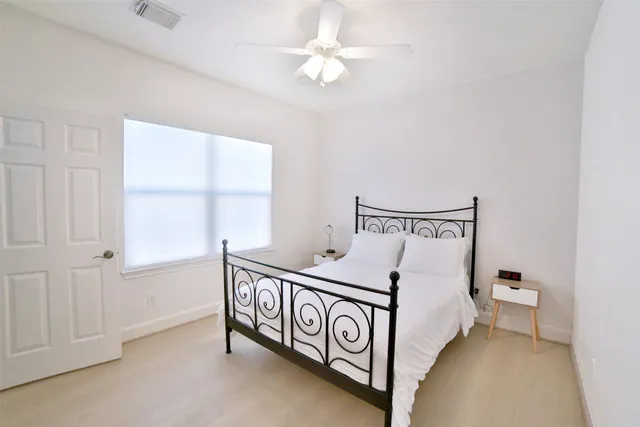 a spacious bedroom with a bed and a window