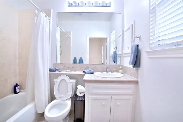 a bathroom with a granite countertop toilet sink and mirror