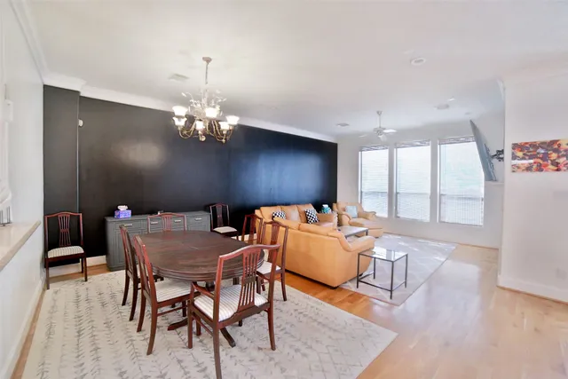 a dining room with furniture a chandelier and wooden floor