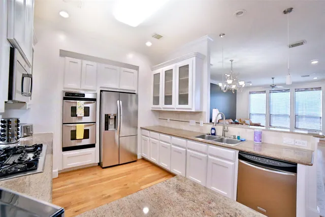 a kitchen with stainless steel appliances granite countertop a refrigerator and a sink
