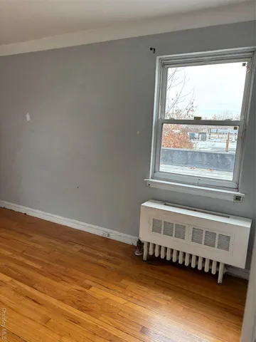 a view of a room with wooden floor and windows