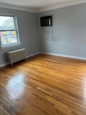 a view of a room with wooden floor and window