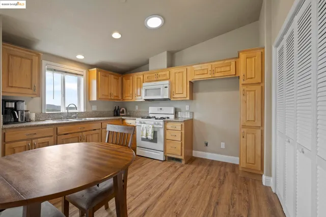 a kitchen with a table chairs refrigerator a sink and cabinets