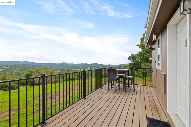 a view of a balcony with chairs and wooden floor