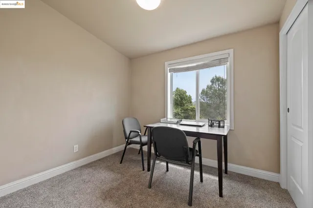 a view of a workspace with furniture and a window