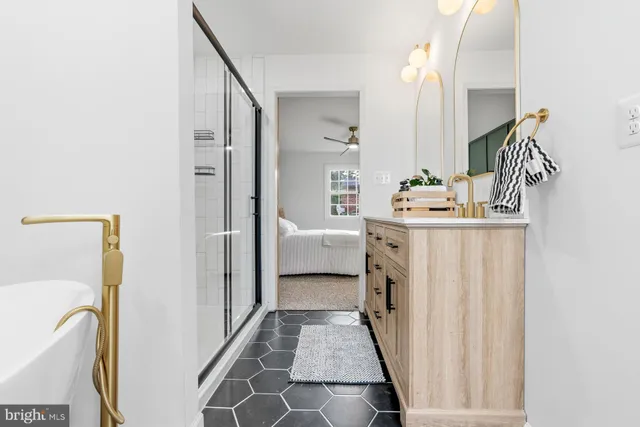 a en suite bathroom with a sink a mirror and a bathtub
