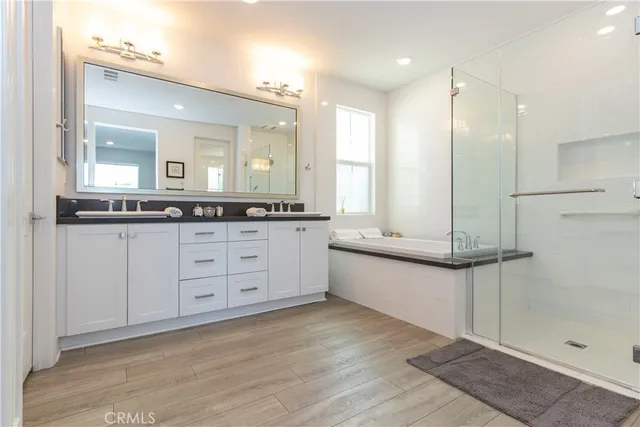 a bathroom with a double vanity sink a mirror and a shower