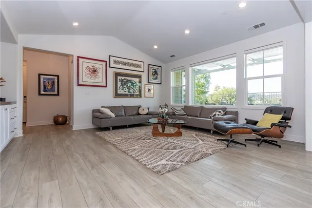 a living room with furniture or couch and a dresser next to a window