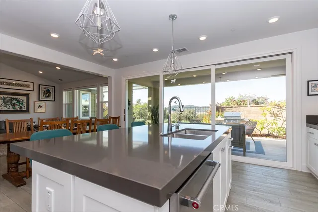 a kitchen with stainless steel appliances granite countertop a sink a stove and a wooden floors