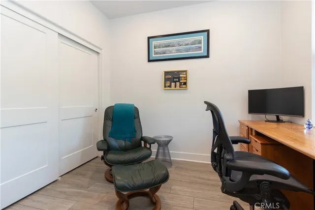 a bedroom with a bed a computer on the desk and a window