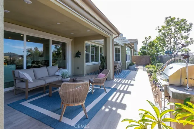 a view of a patio with couches table and chairs and potted plants