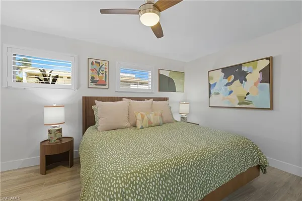 a bedroom with a bed and painting on the wall