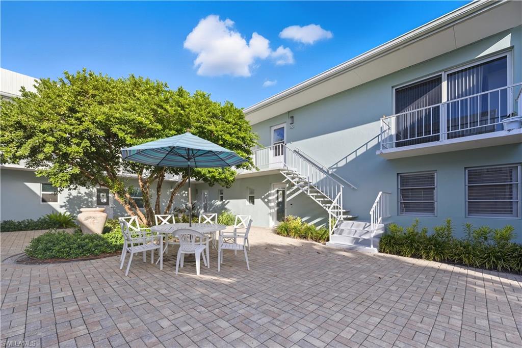 609 12th Avenue South, Unit 609 Naples, FL 34102 - Photo 2 of 32 a table and chairs in a patio