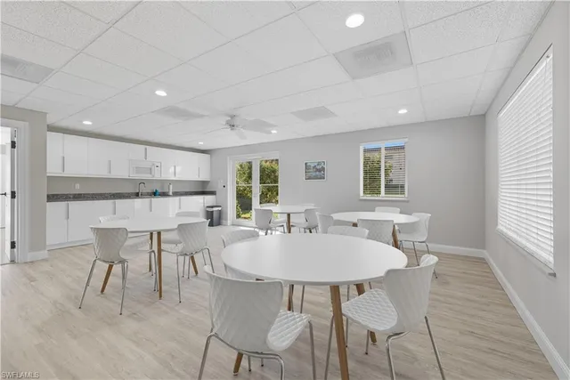 a kitchen with kitchen island a dining table and chairs