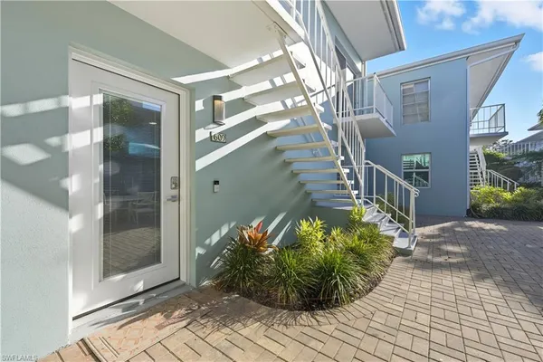a view of a entryway door with potted plants