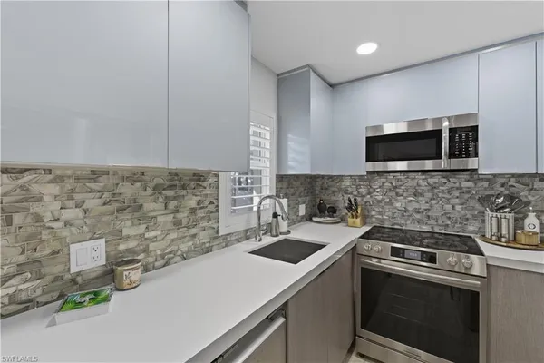 a kitchen that has a sink and a stove top oven