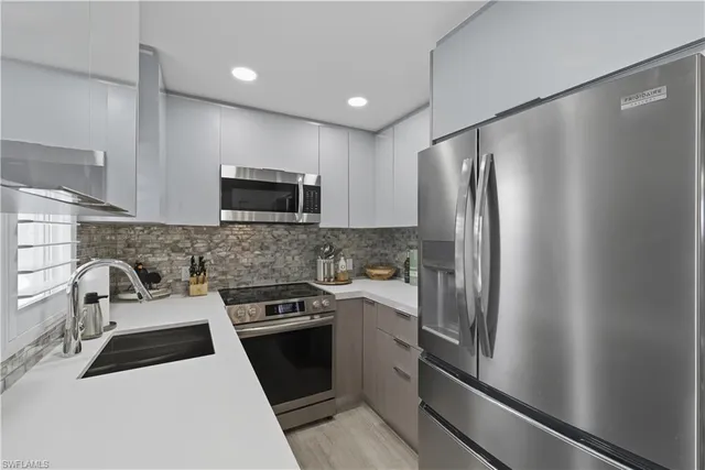 a kitchen with stainless steel appliances a refrigerator sink and microwave