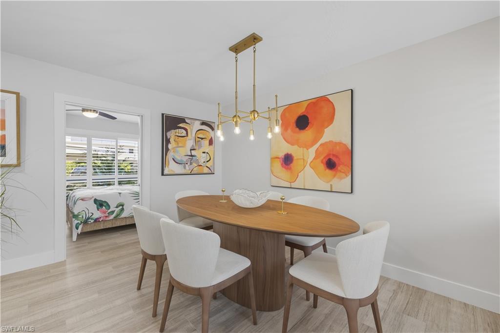 609 12th Avenue South, Unit 609 Naples, FL 34102 - Photo 10 of 32 a view of a dining room with furniture and wooden floor
