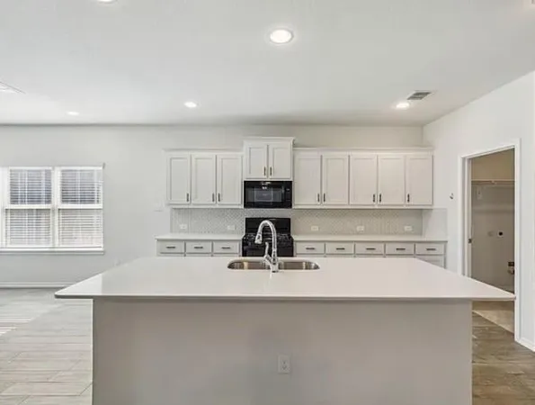 a kitchen with a sink a stove and cabinets