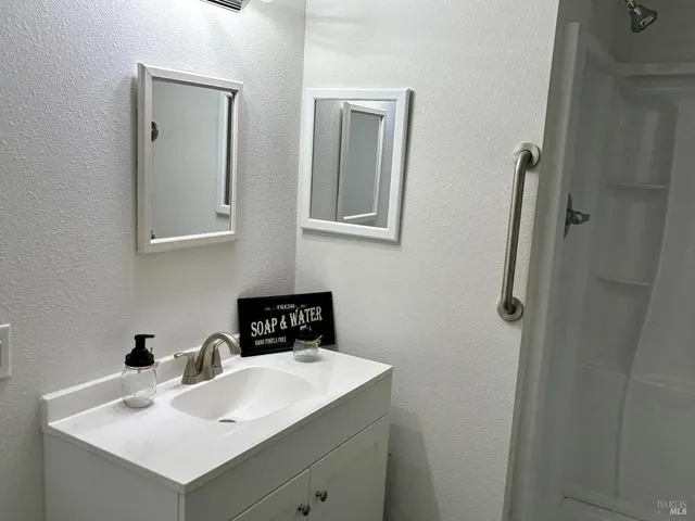 a bathroom with a sink vanity and mirror