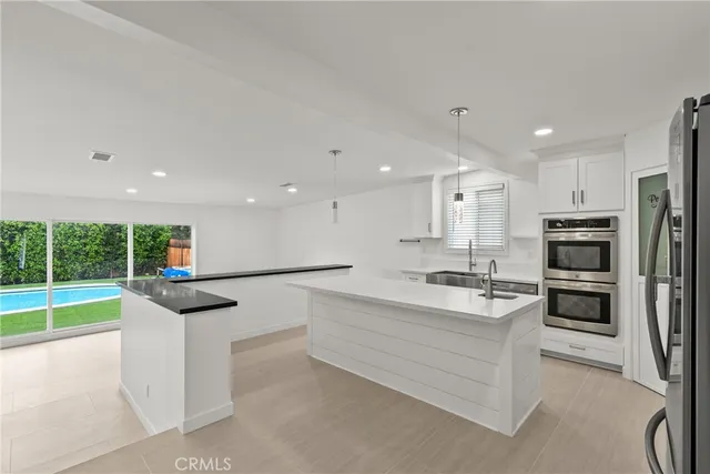 a kitchen with stainless steel appliances kitchen island sink refrigerator and stove